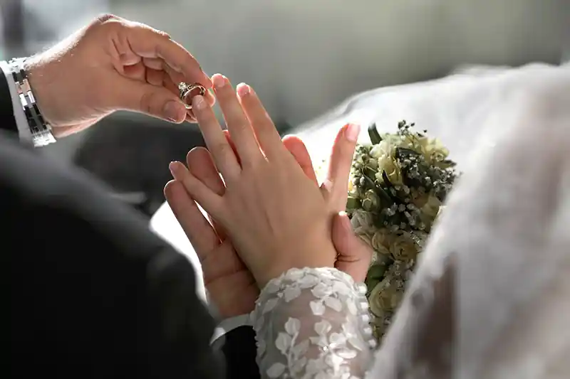 کلوزآپ حلقه های ازدواج و دست های عروس و داماد